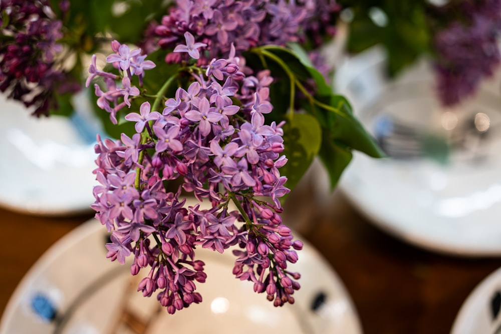 a vase filled with purple flowers on top of a table