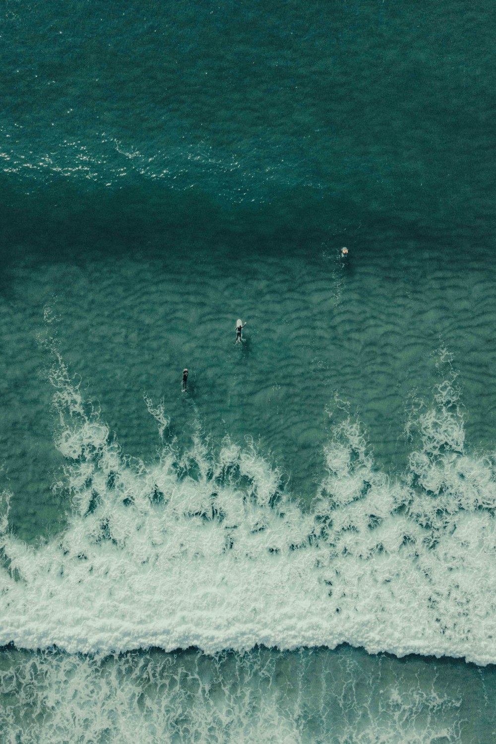 a group of people riding surfboards on top of a wave