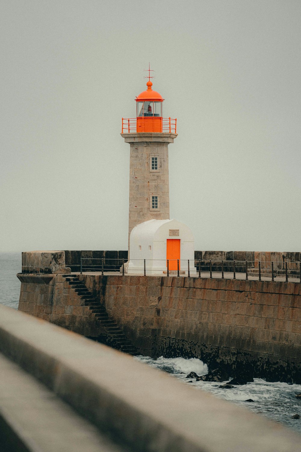 a light house sitting on top of a pier next to the ocean