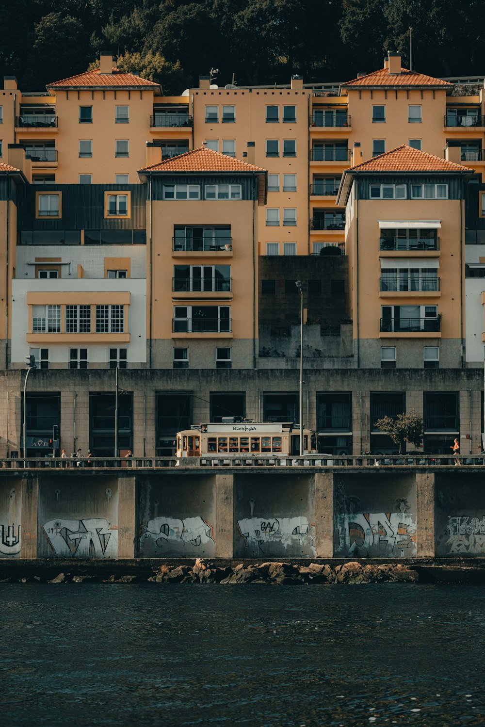 a building with graffiti on the side of it next to a body of water