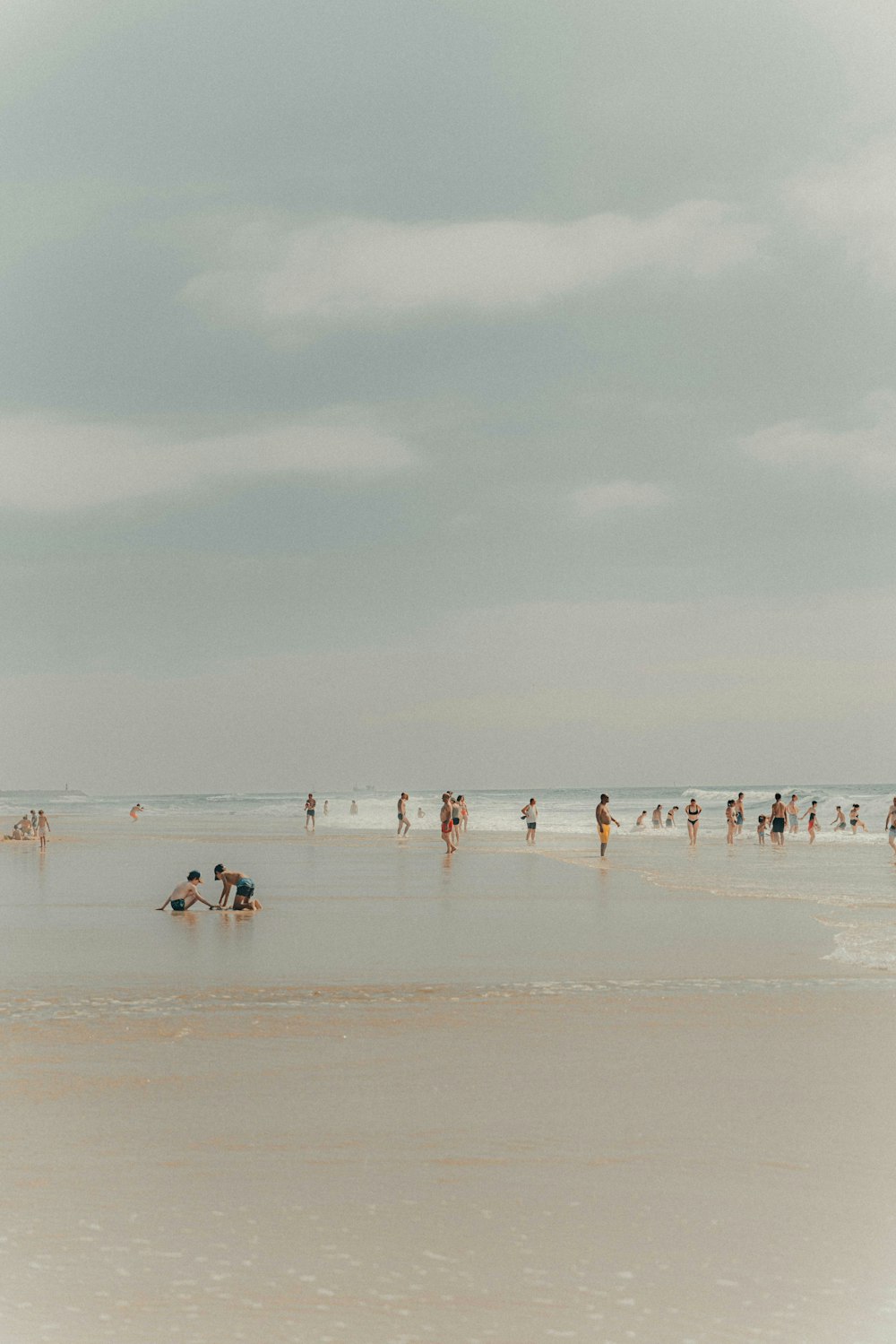 a group of people standing on top of a sandy beach