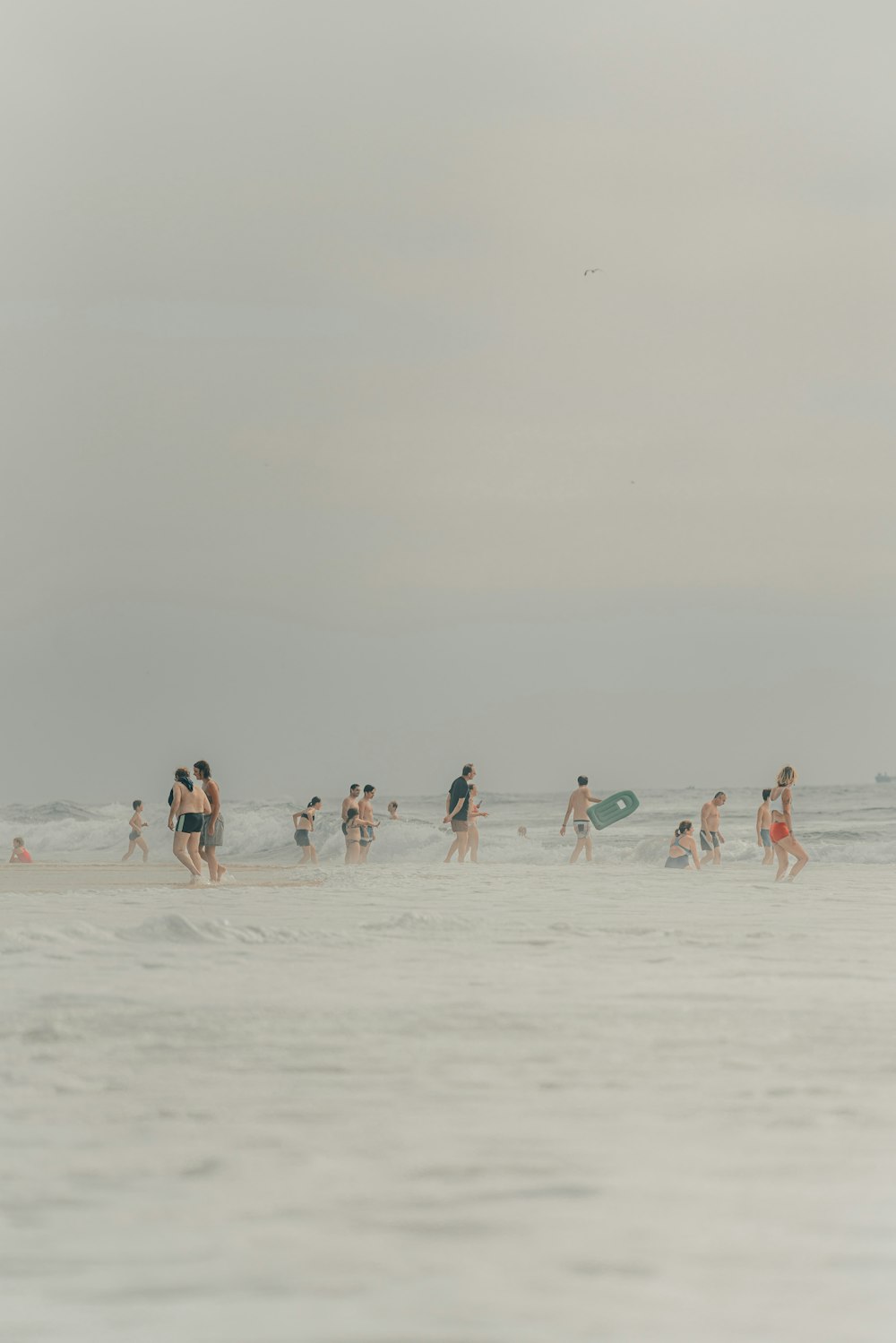 a group of people walking along a beach next to the ocean