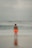 a man standing on a beach next to the ocean