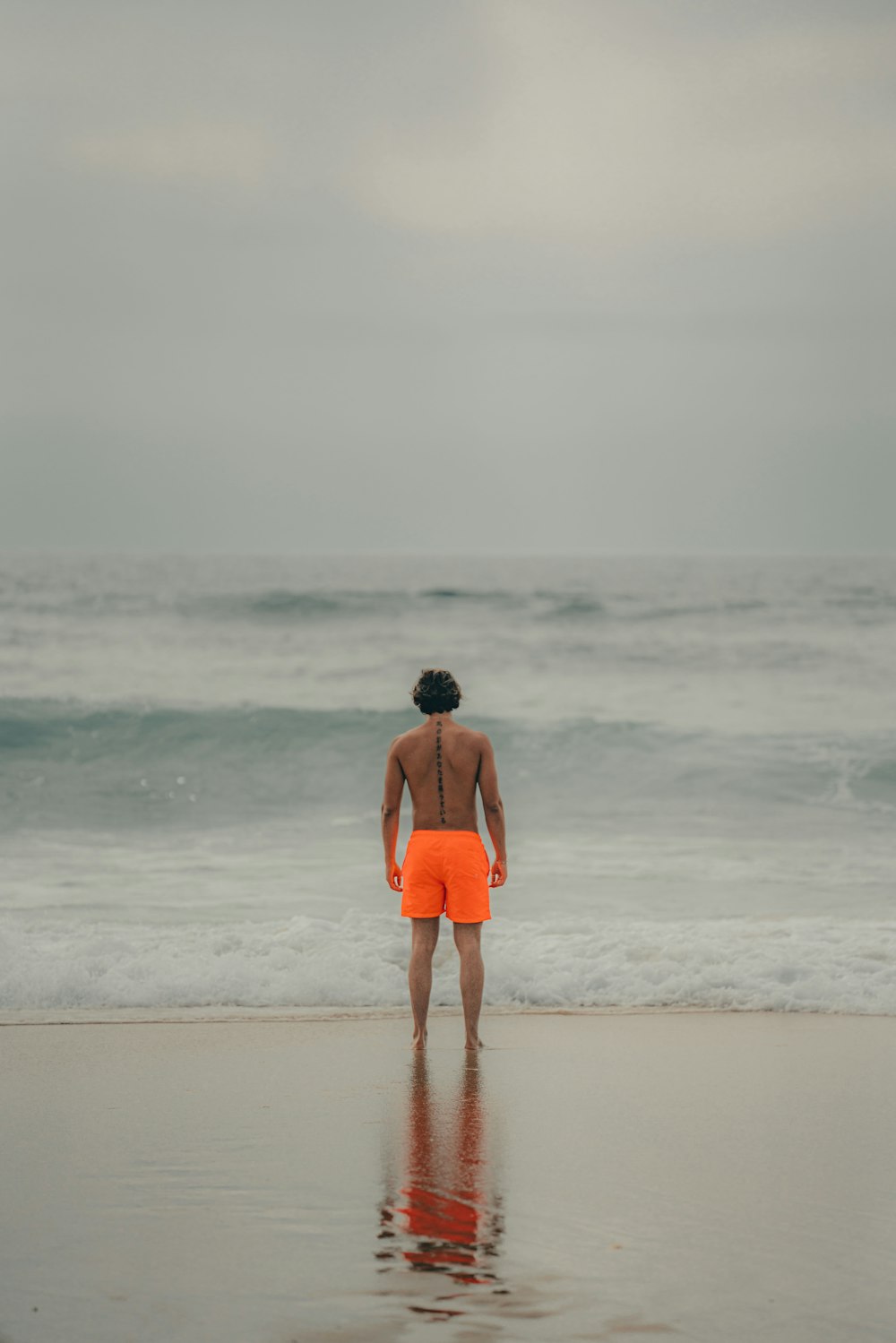 a man standing on a beach next to the ocean