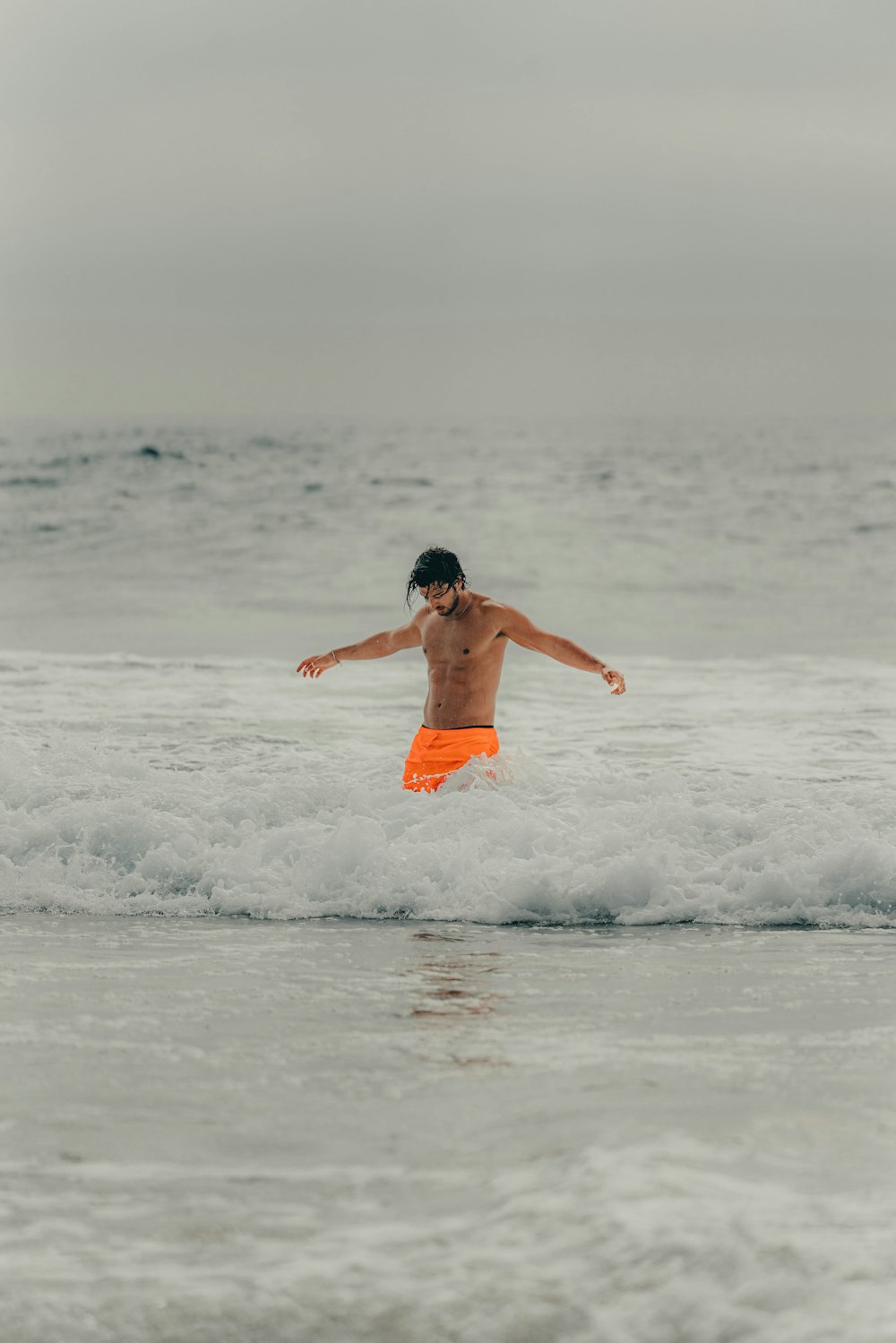 a young boy is jumping in the water at the beach