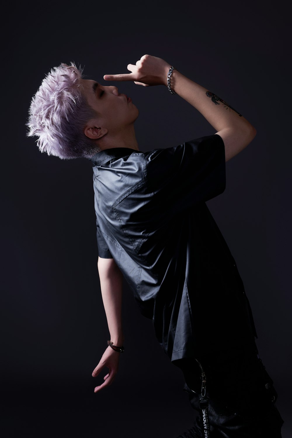 a man with purple hair is posing for a picture