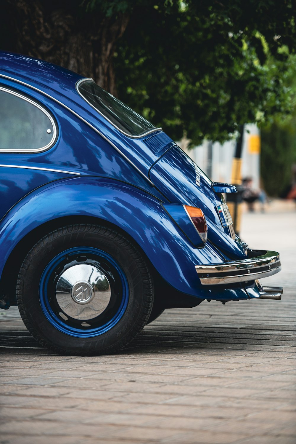 a blue vw bug parked on the side of the road