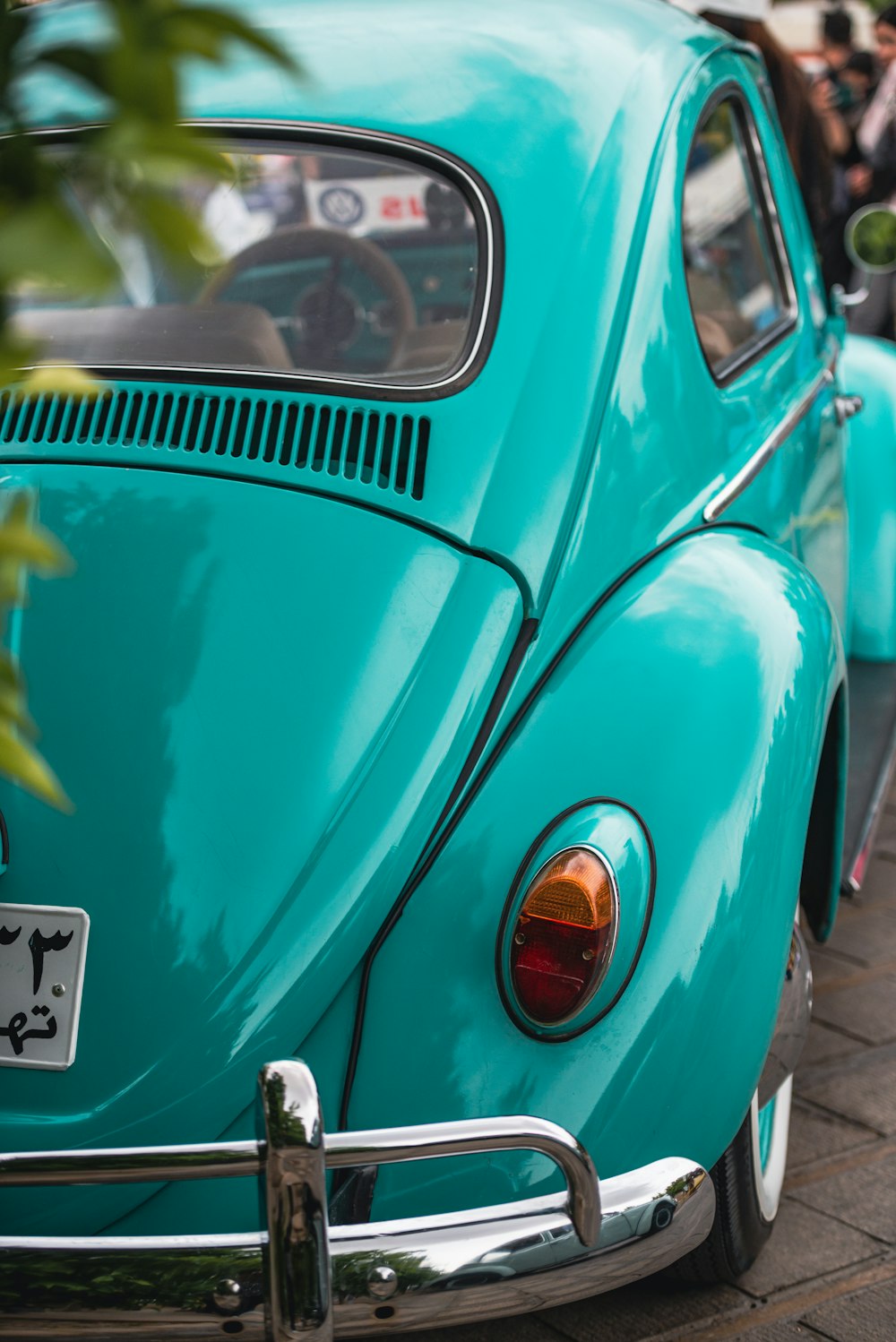 a blue vw bug parked on the side of the road