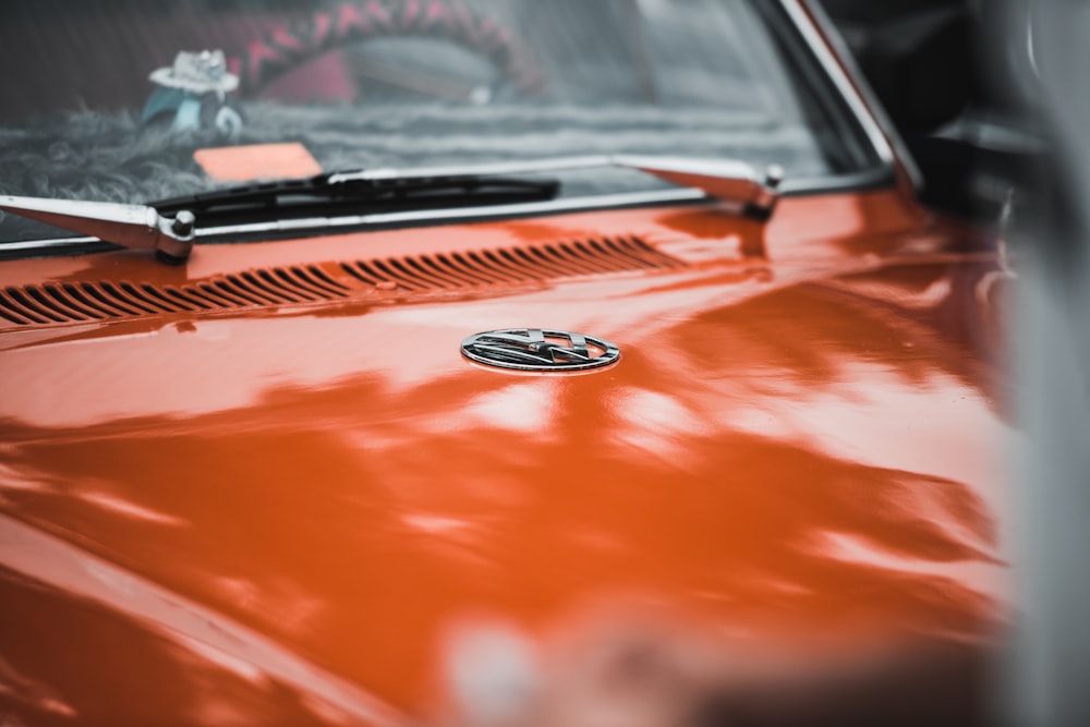 a close up of the hood of an orange car