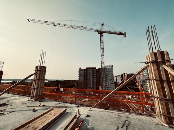 A busy construction site with workers handling various building materials under a clear sky.