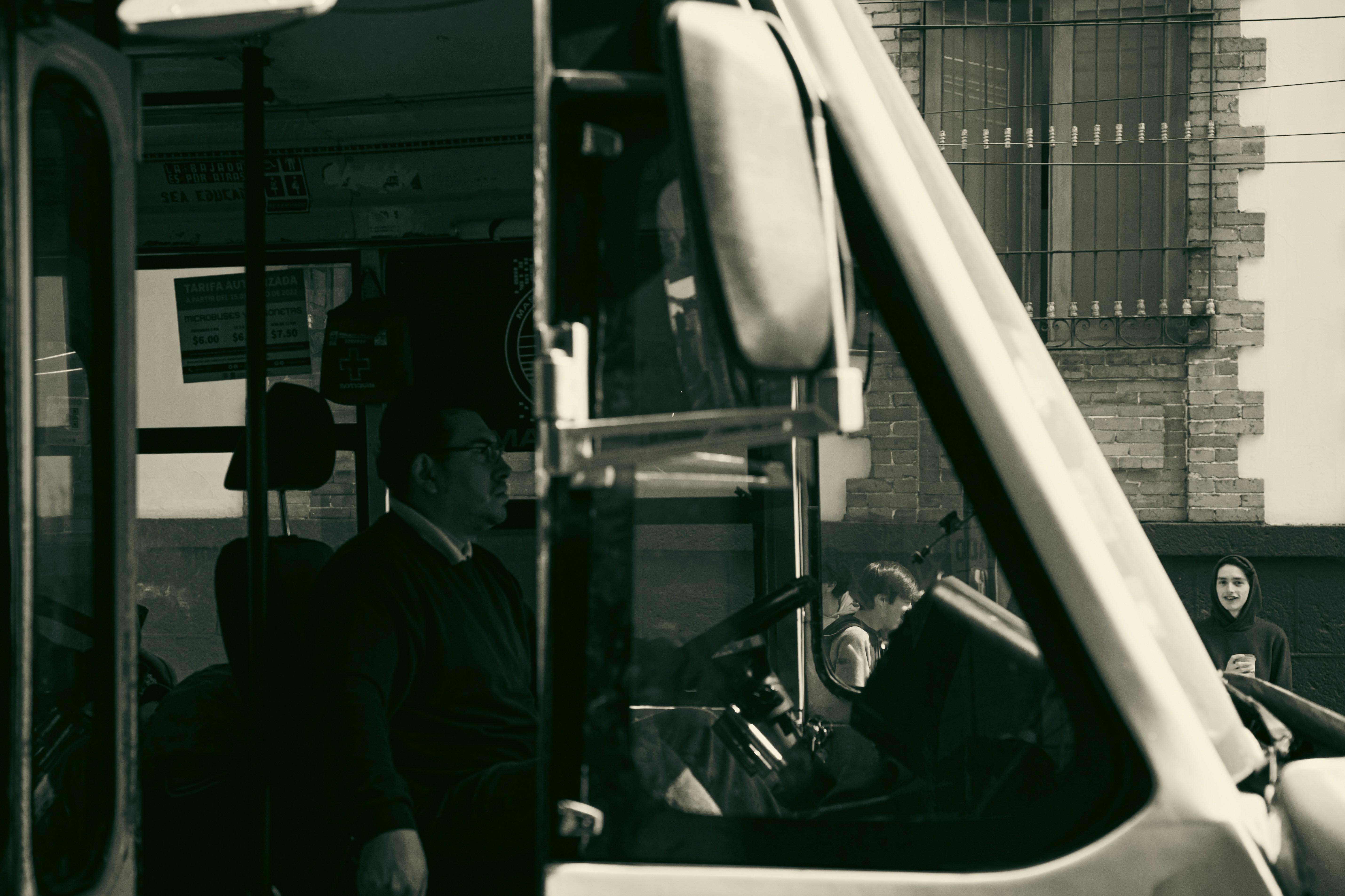 a black and white photo of a bus driver, 