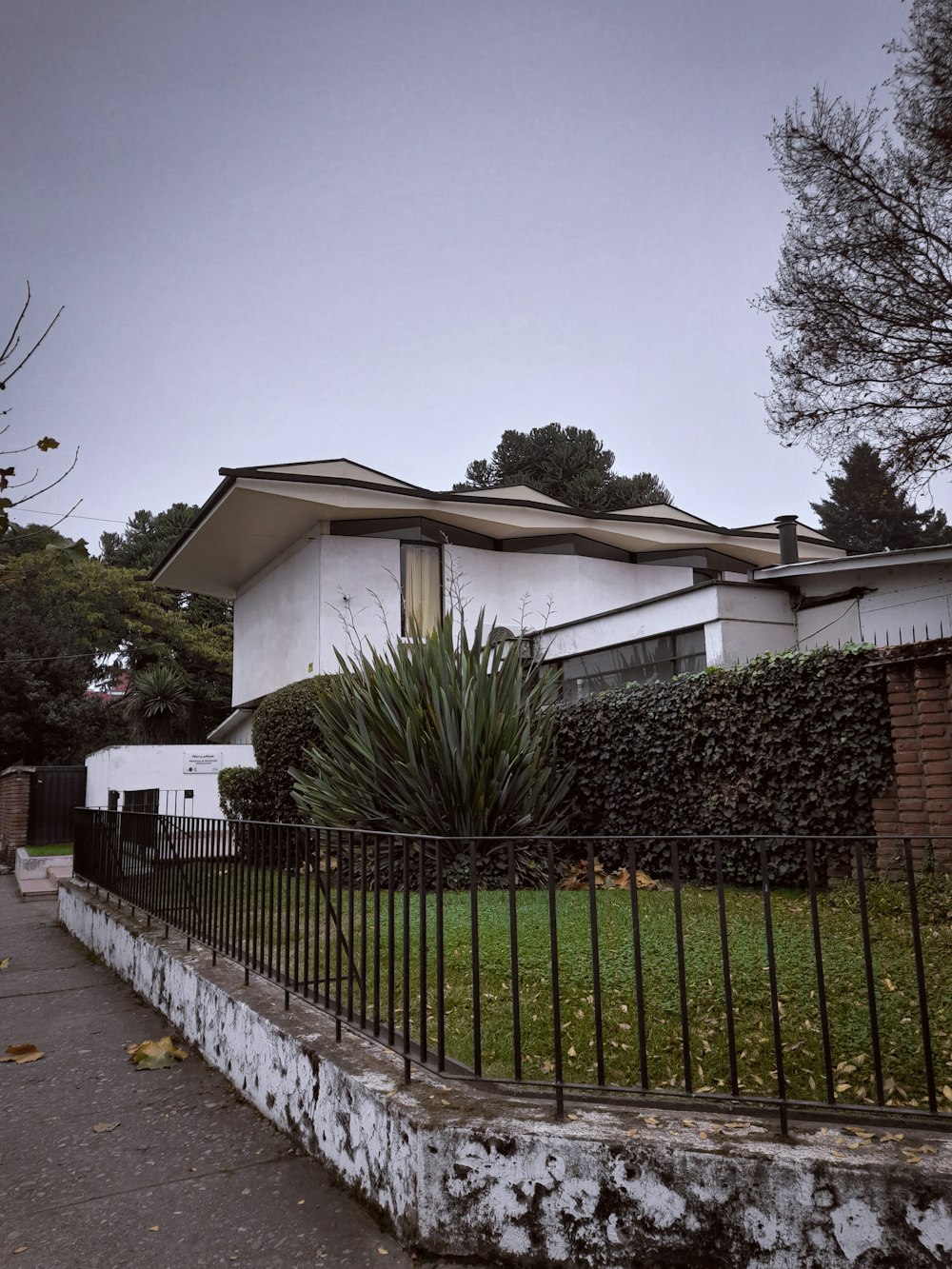 a white house with a black fence in front of it