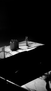 a black and white photo of a table with two vases on it