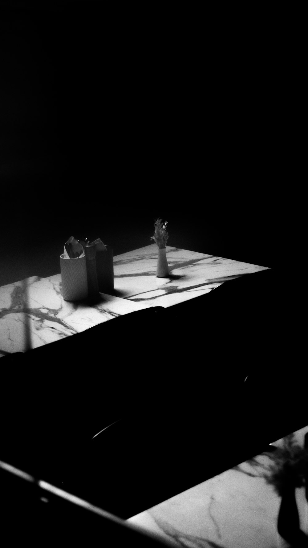 a black and white photo of a table with two vases on it