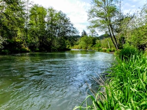 A peaceful river flowing through a green valley, reflecting calmness and trust in divine guidance.