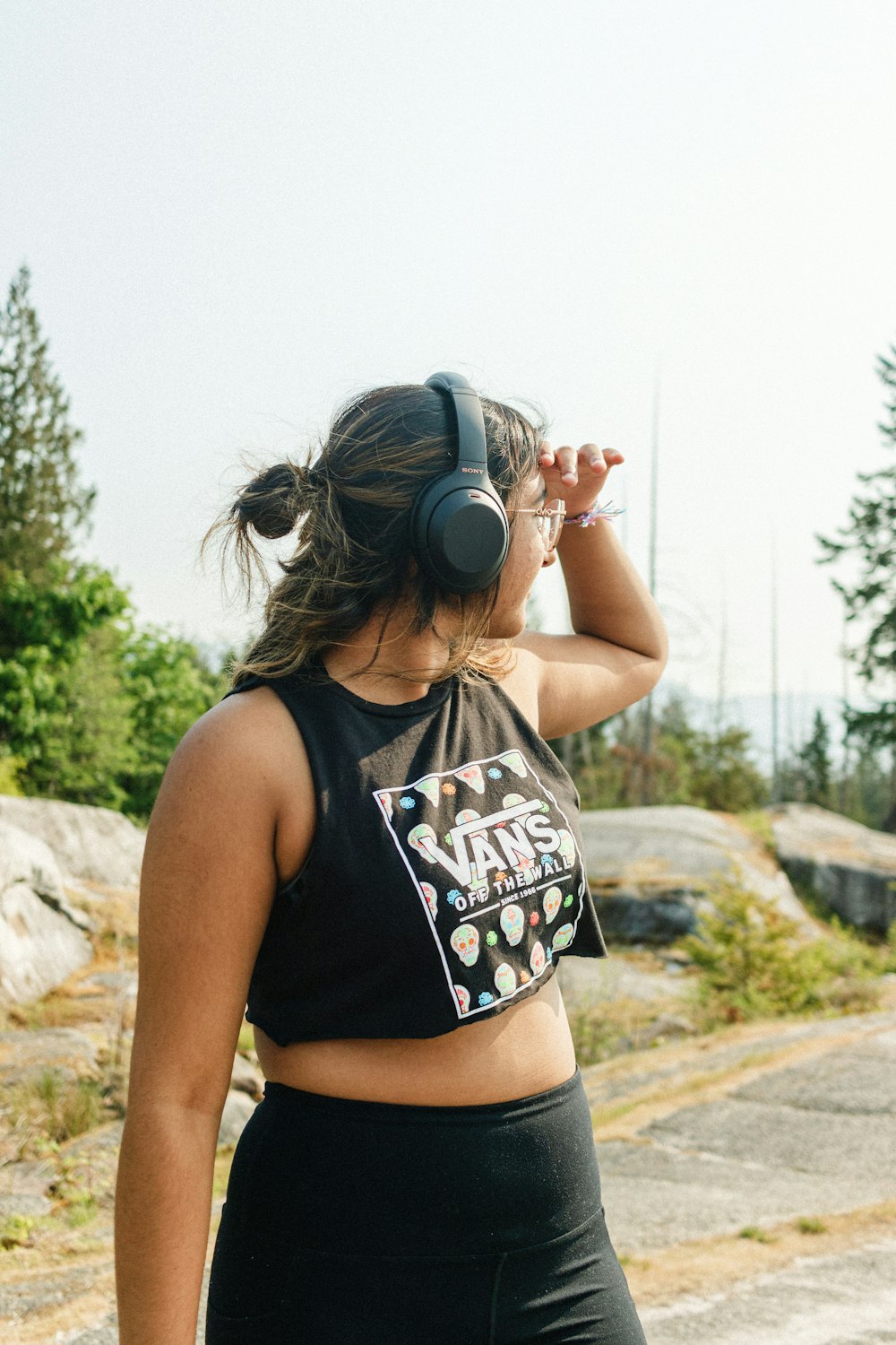a woman with headphones on walking down a road