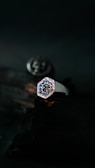 A silver men's ring with a minimalist design against a dark background.