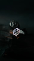 A stylish silver ring engraved with delicate patterns, displayed on a rustic wooden background.
