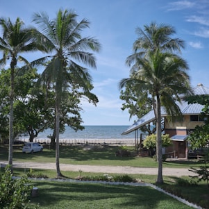 A bright tropical scene showing a happy customer receiving keys to a rental car on a sunny beach in Guyana.