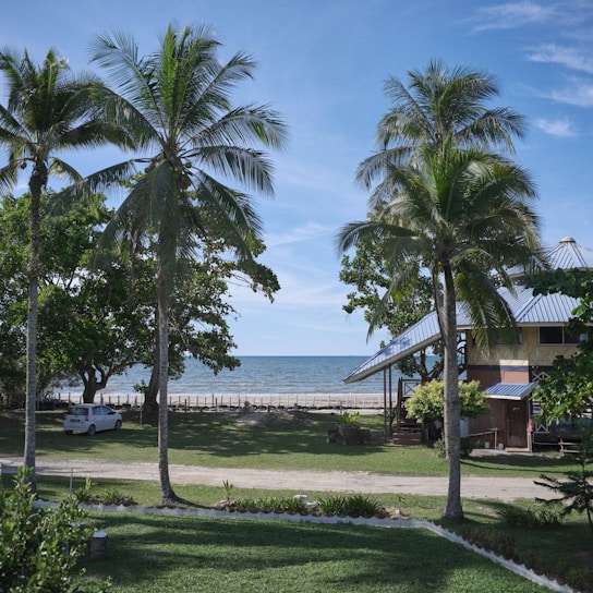 A bright tropical scene showing a happy customer receiving keys to a rental car on a sunny beach in Guyana.