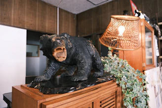 Handcrafted bear-shaped wooden wall art hanging above a stone fireplace.