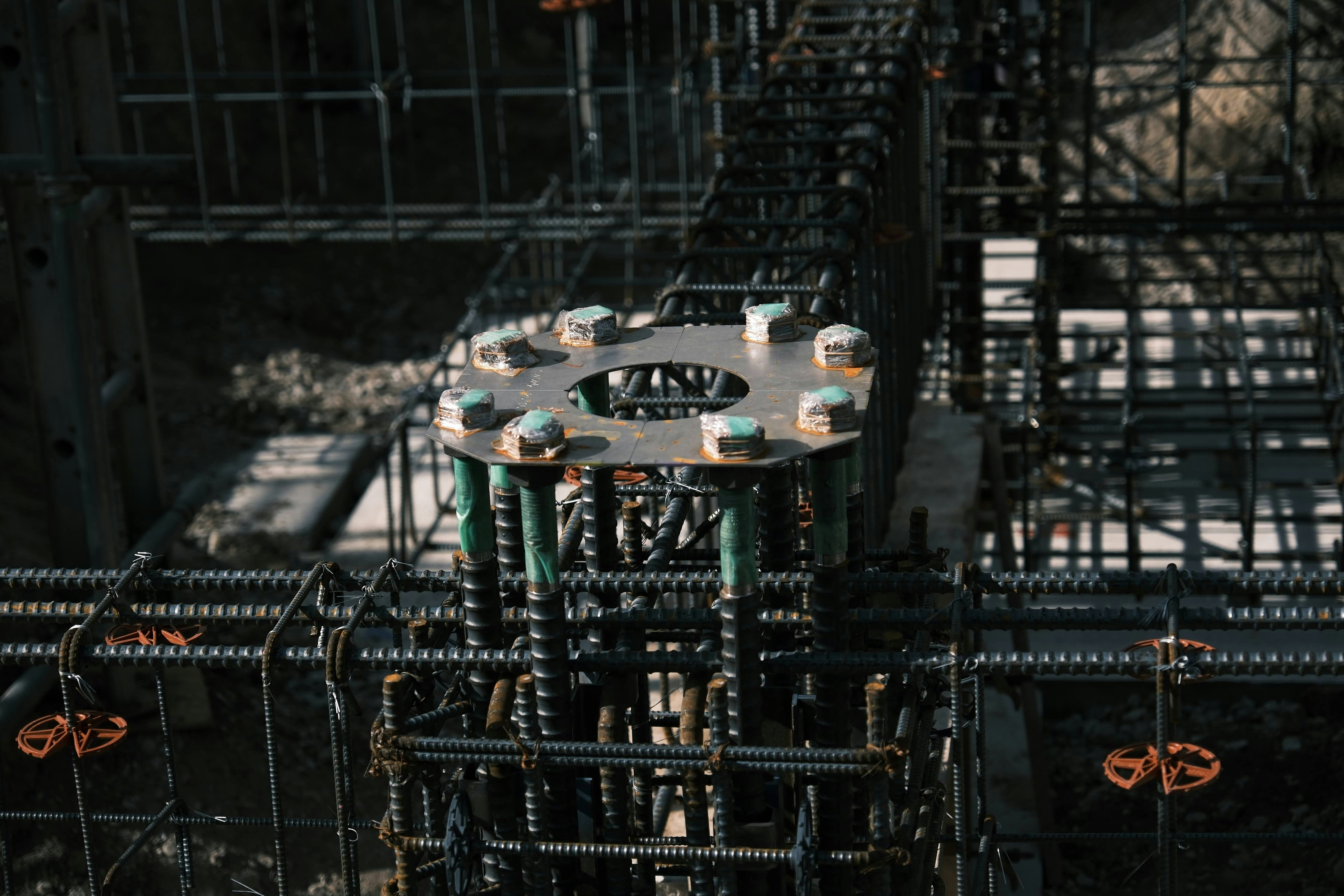 Bridge construction foundation work, steel reinforcement bars visible, wet concrete forms, industrial construction atmosphere