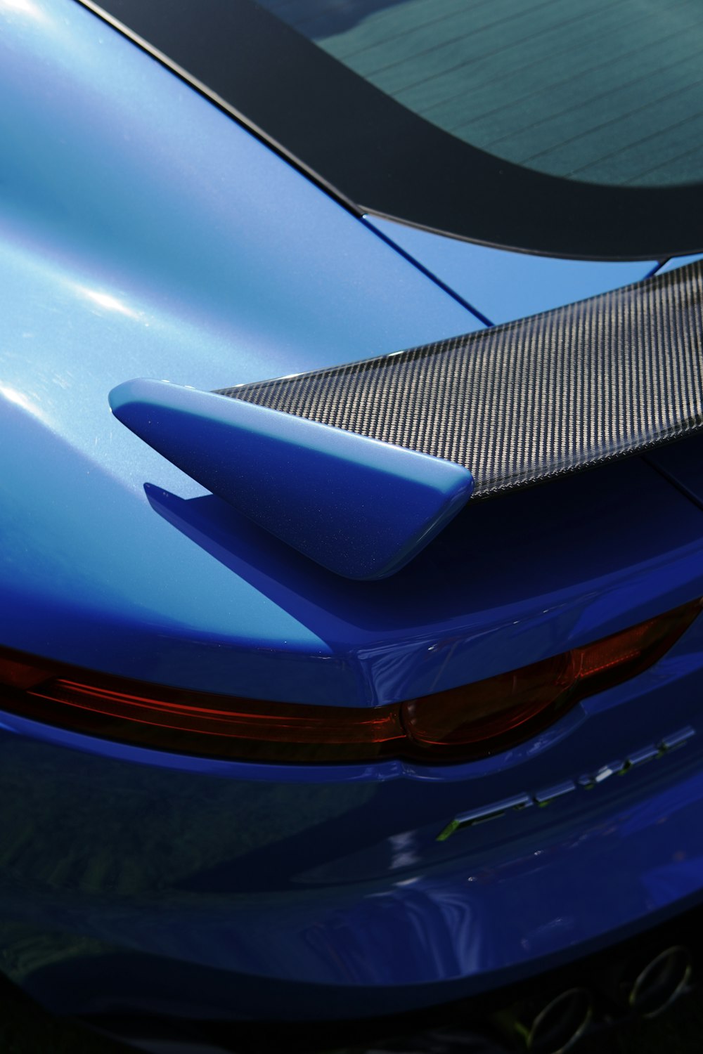 a close up of the tail end of a blue sports car