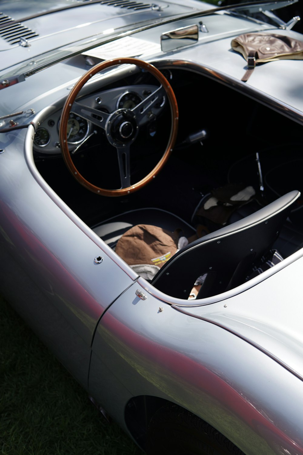 a silver sports car with a wooden steering wheel