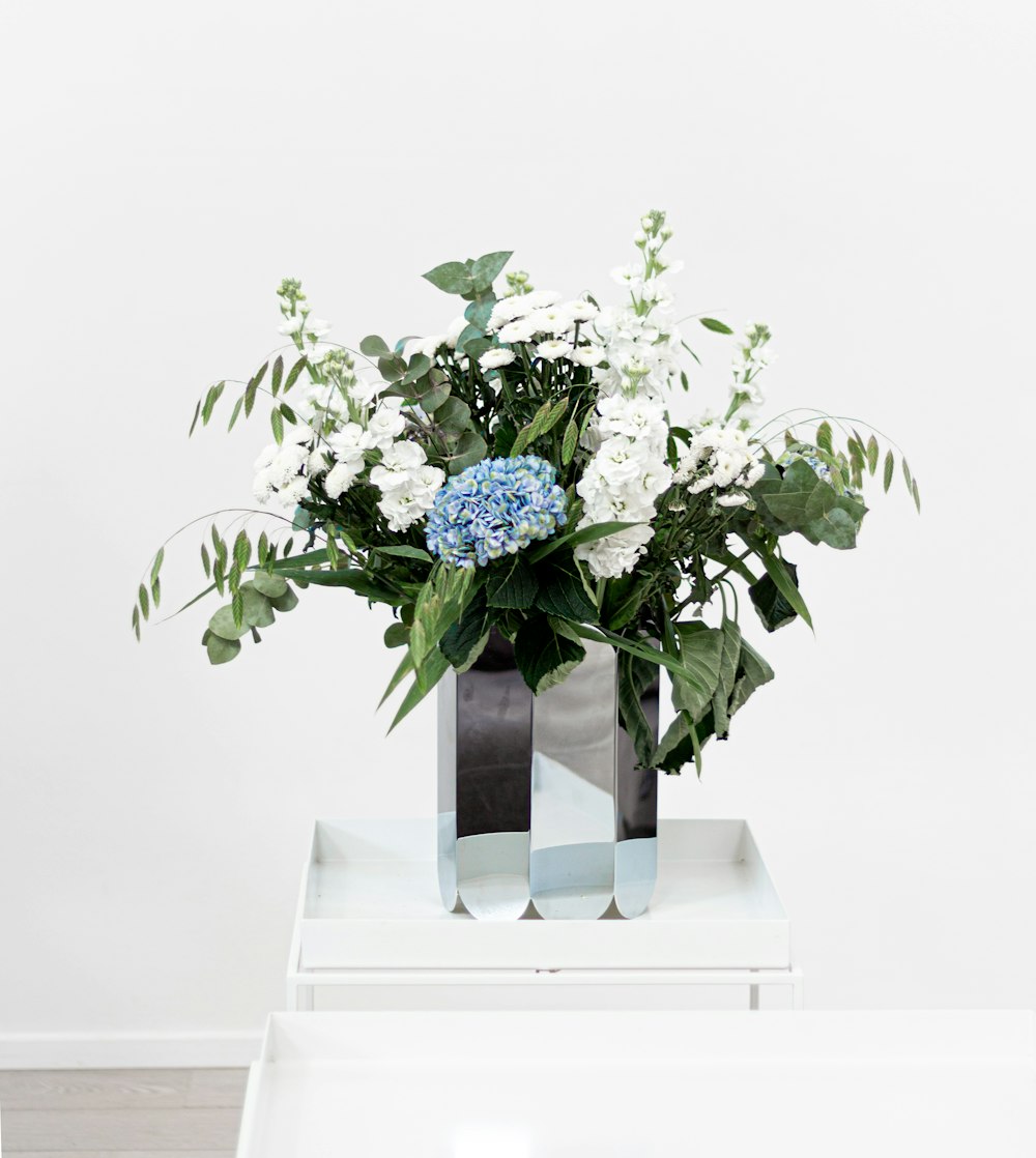 a vase filled with white and blue flowers