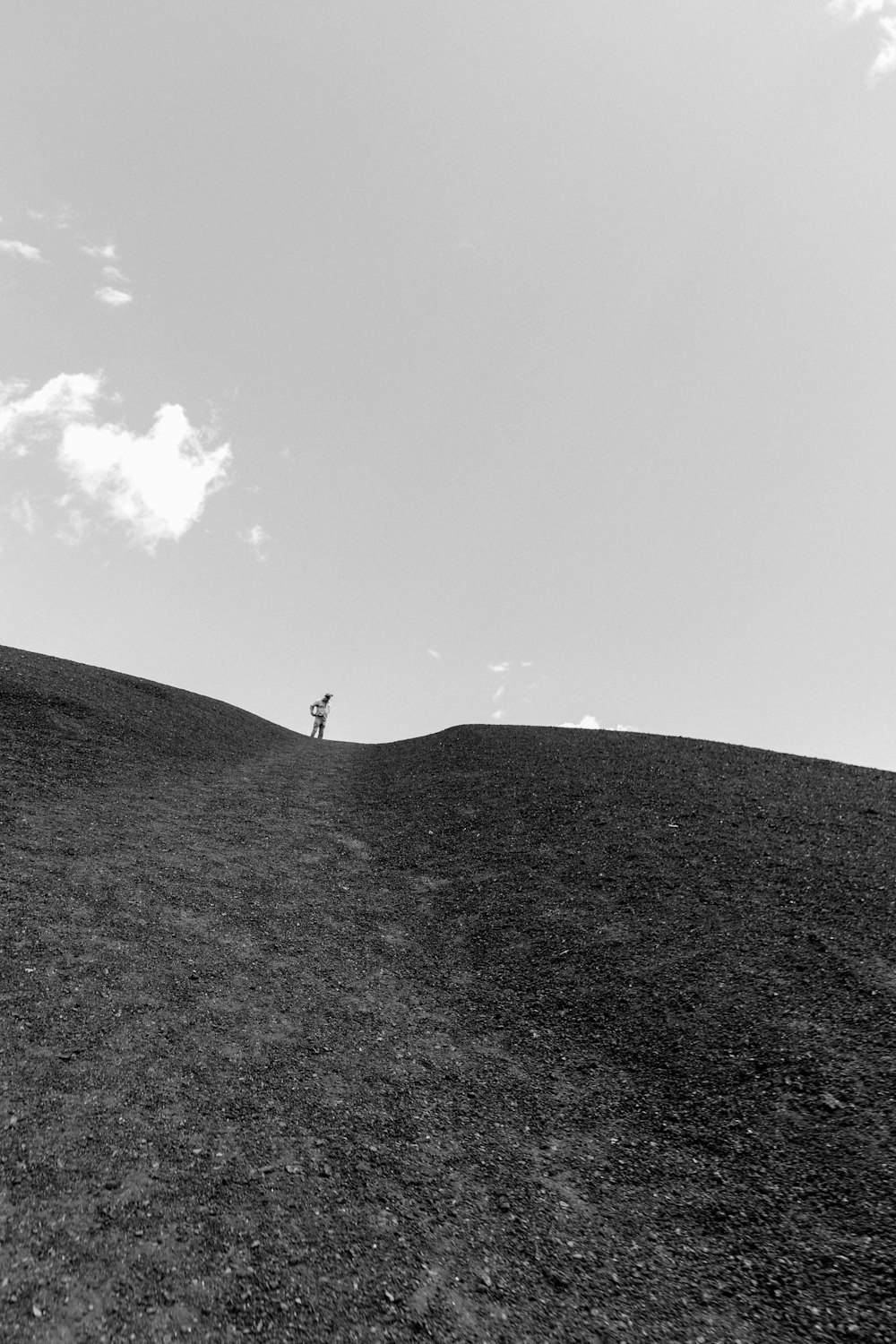 a person standing on top of a hill flying a kite