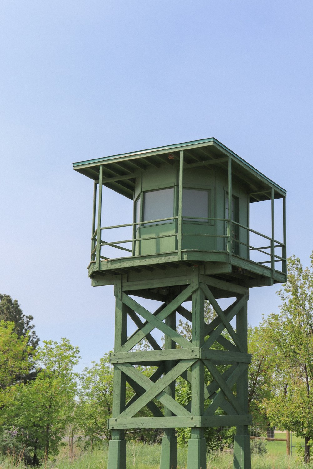 a tall green tower sitting on top of a lush green field