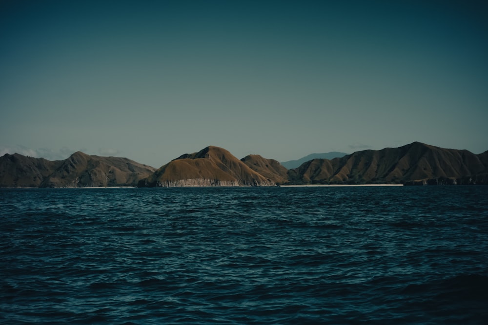 a large body of water with mountains in the background