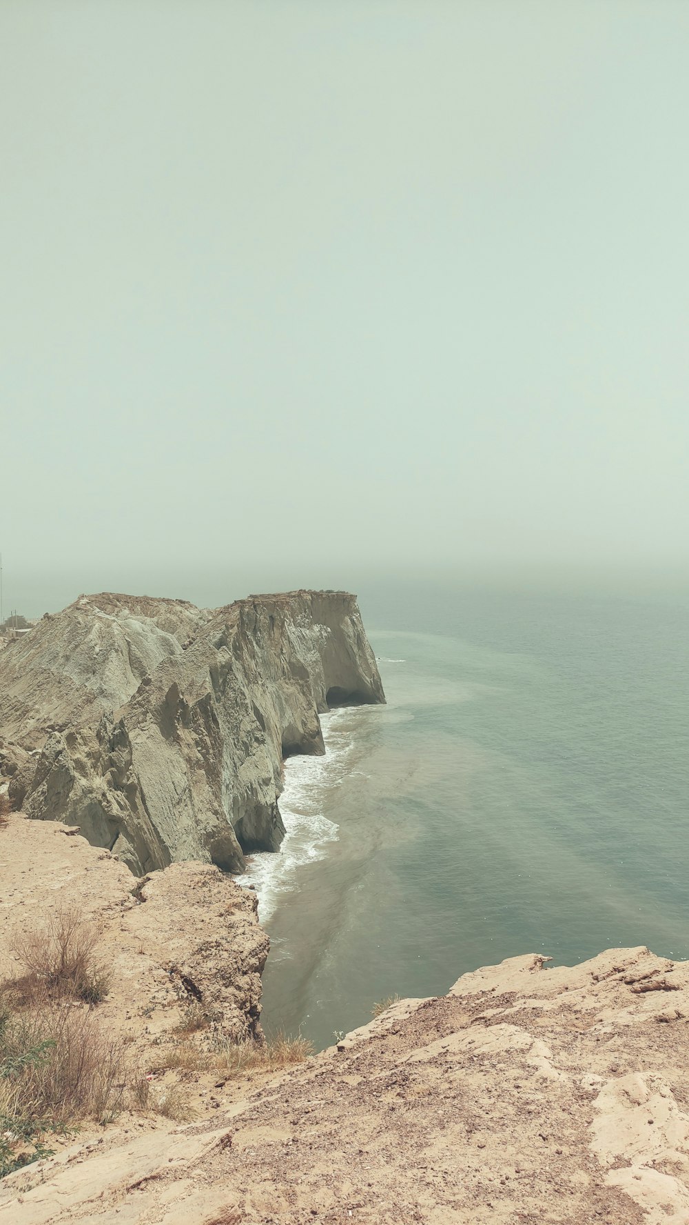 a person standing on top of a cliff near the ocean