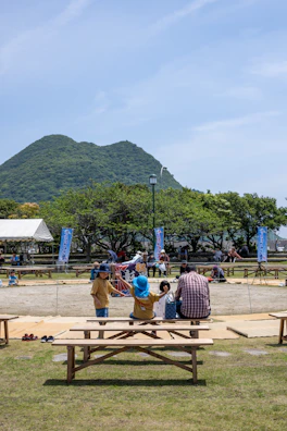 A community gathering with families sharing smiles and stories under a clear blue sky