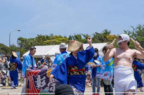 A friendly guide assisting a foreign visitor at a vibrant Okinawa cultural event.