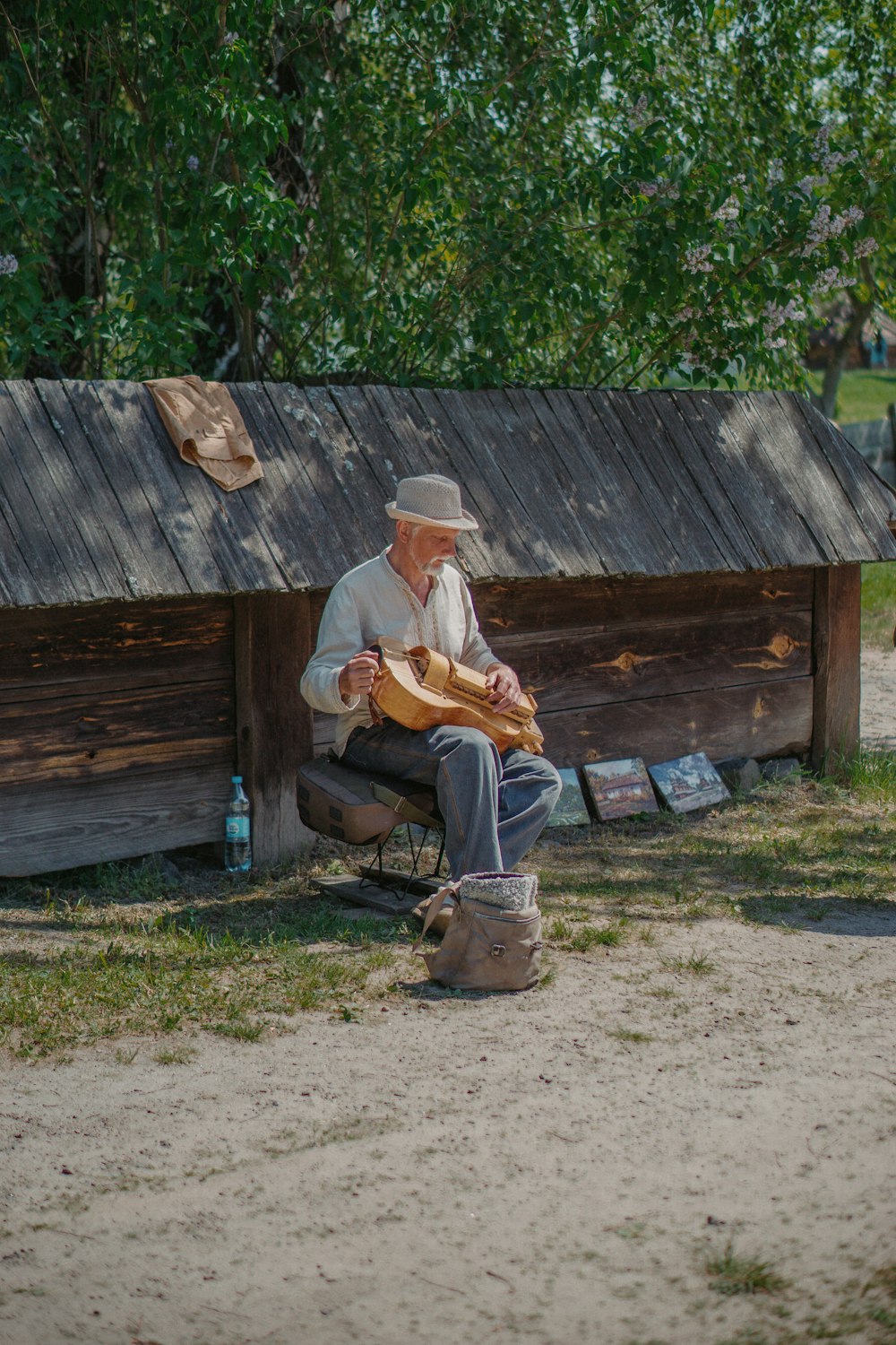 a man sitting on a bench in front of a shack