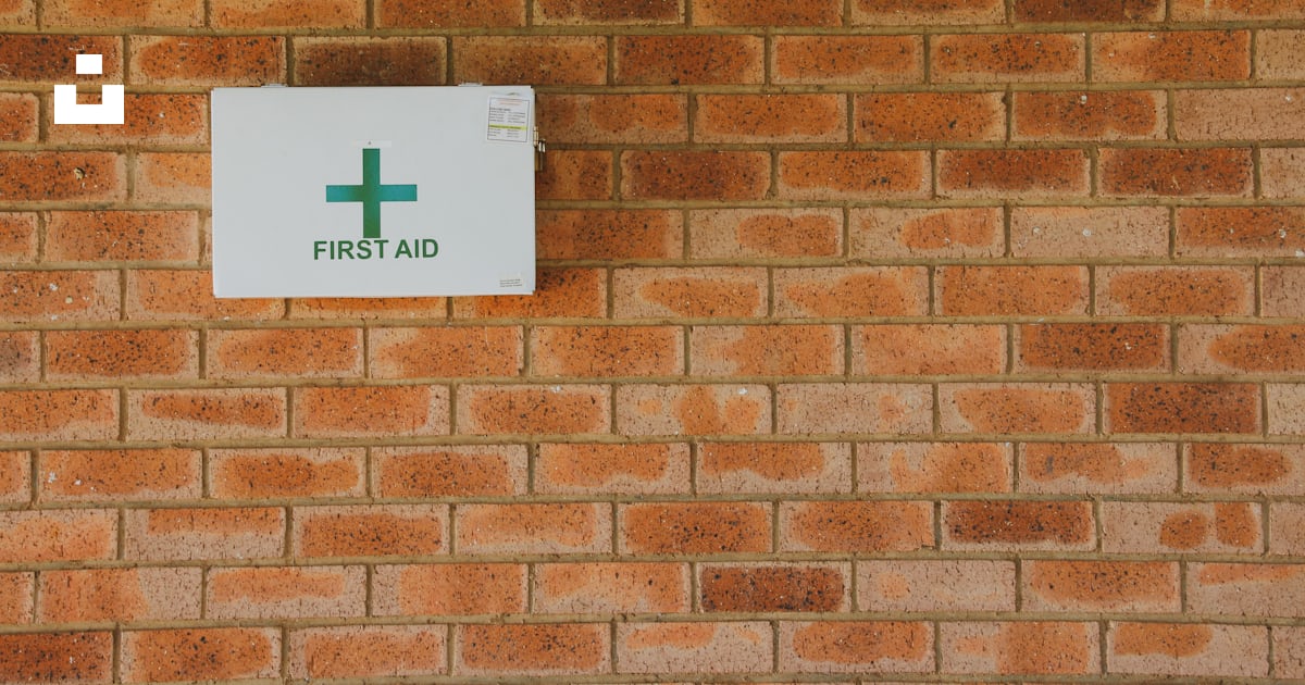 A first aid sign on a brick wall photo – Free First aid Image on Unsplash