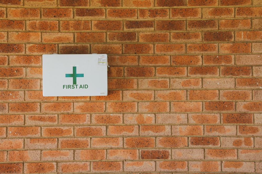 a first aid sign on a brick wall