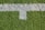 A patch of artificial grass with a thick white line running horizontally across it, intersected by a shorter vertical white line.