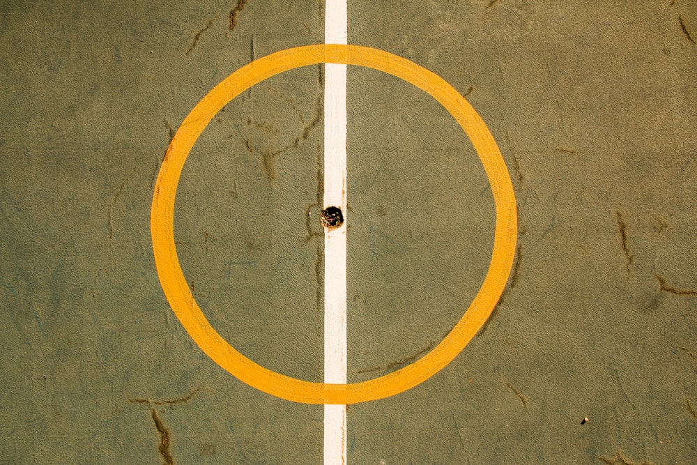 an overhead view of a tennis court with a yellow ring