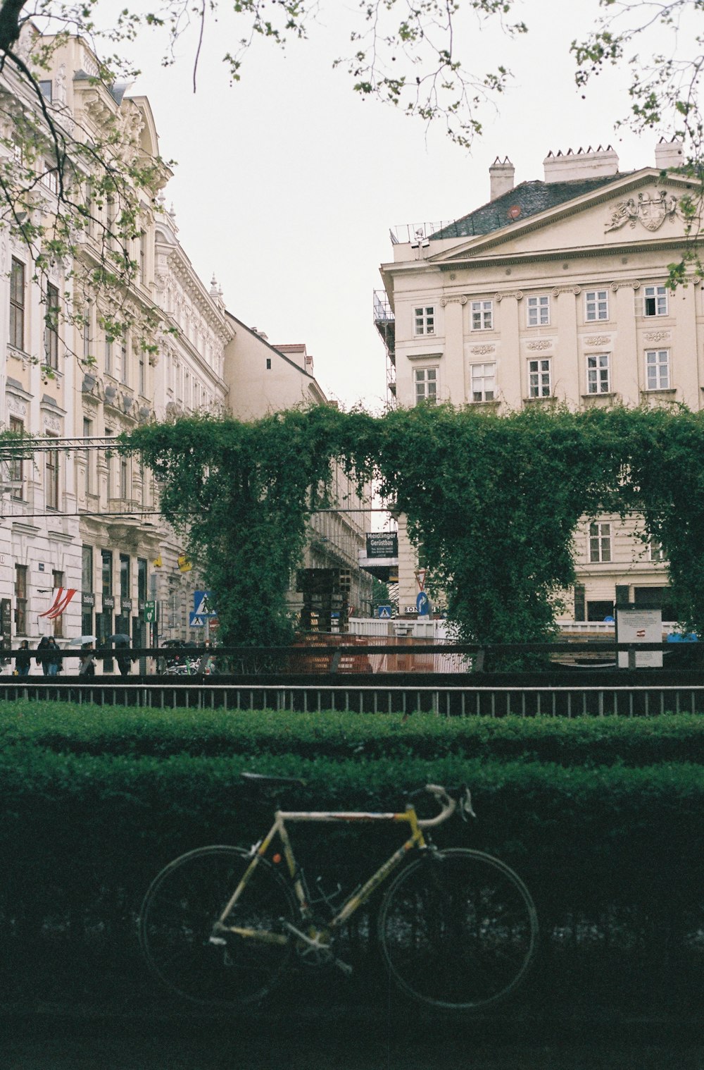 a bike is parked in front of a hedge