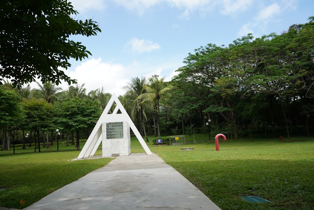 a white sculpture in the middle of a park