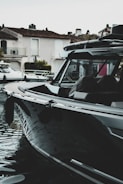 Sleek black boat with freshly applied protective film on a calm marina.