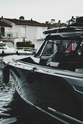 Wide shot of a sleek new boat docked at a modern marina under clear skies