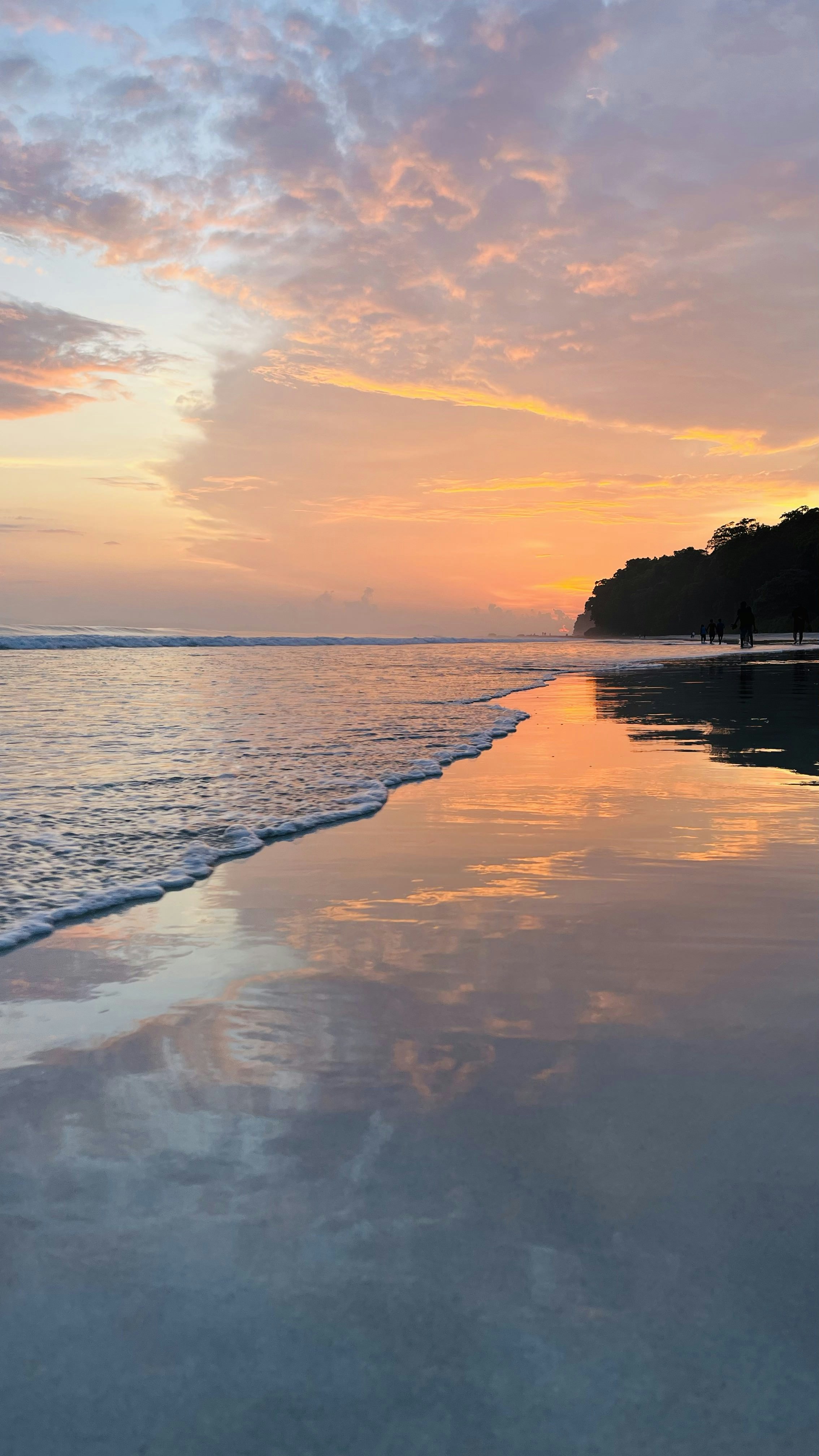Golden sunset over calm ocean at Siesta Key beach with warm orange and pink sky reflections on water