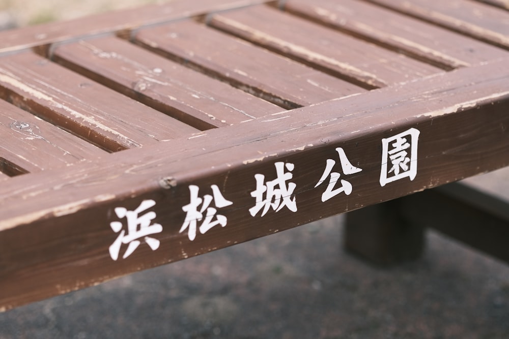 a wooden bench with asian writing on it