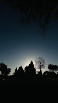 A serene temple silhouette against a twilight sky with glowing diyas.