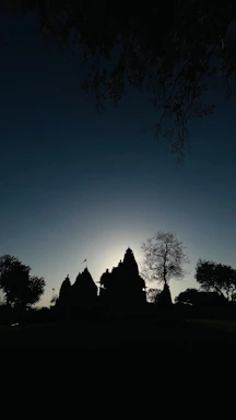 A serene temple silhouette at sunset with soft glowing lights.