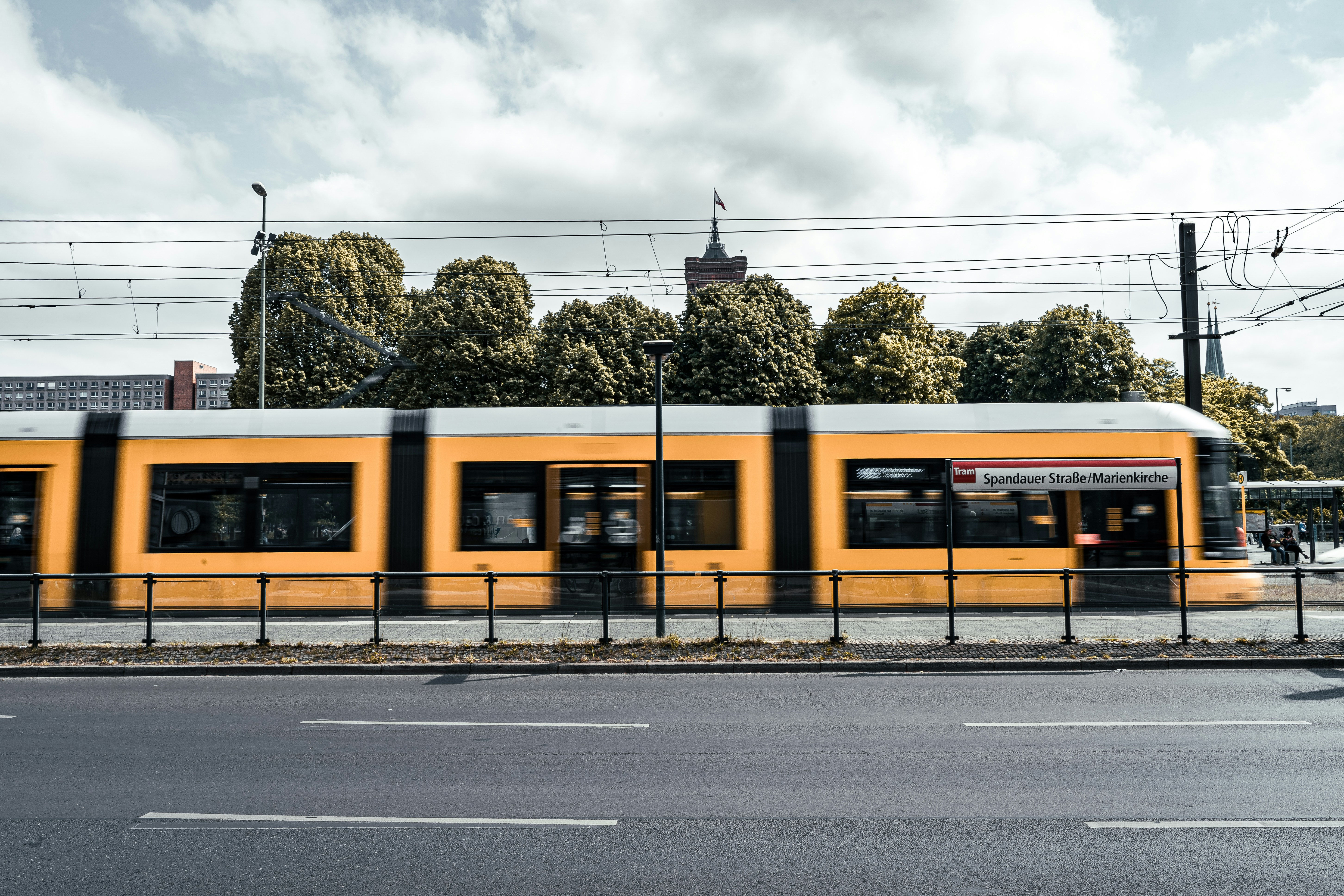 a yellow train traveling down train tracks next to a street