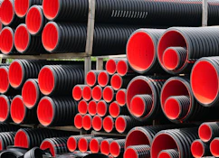 a pile of red and black pipes stacked on top of each other